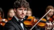 © angel_nt - talented violinist captivates the audience with his skillful playing in a formal setting. evening concert features a full orchestra, creating a rich, harmonious sound