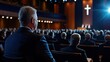 © Formoney - A man in a suit sits in a large auditorium with a cross on the stage