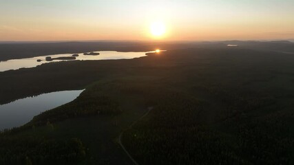 Wall Mural - Aerial footage of the sunset over the Angesan forest river in Overkalix in Norrbotten County, Sweden