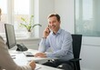 © IbragimovN - Businessman in office smiling while on phone call with colleague