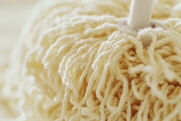 Poster - A close-up view of a mop leaning against a table, ready for use