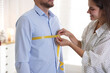 © New Africa - Woman measuring man's chest with tape in atelier
