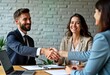 © Pete - Businesspeople shake hands during job interview. Smiling applicants, recruiters sit at table in office. Job offer agreement likely made. Pro business setting. Potential employee, employer. Positive