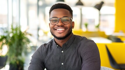 Wall Mural - Smiling african male adult in modern office setting