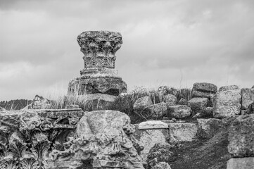 A stone pillar sits on a hillside, surrounded by rocks