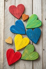 Poster - A row of colorful wooden hearts are arranged on a wooden surface