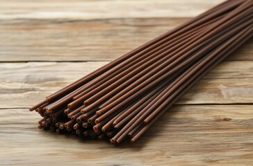 Poster - A Close-Up View of Brown Wooden Sticks Arranged Neatly on a Rustic Wooden Surface for Craft or Culinary Use, Highlighting Natural Texture and Color Variations