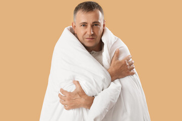 Wall Mural - Mature man with soft blanket on beige background