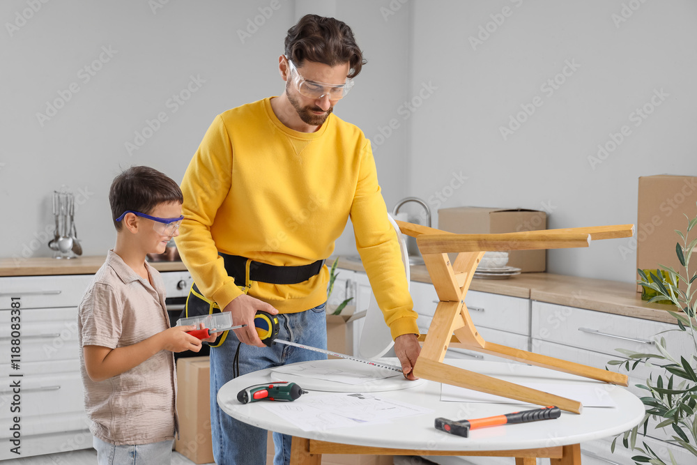 Father with tape measure and his little son assembling chair in kitchen