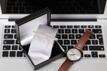 Poster - Box with men's necktie and wristwatch on laptop, closeup