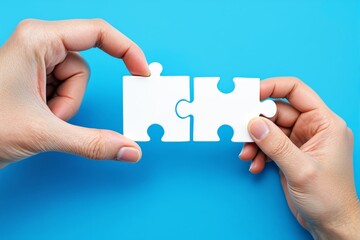 Poster - Two hands holding and connecting white puzzle pieces on a blue background.