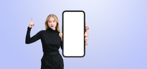 Poster - Woman in black outfit pointing while holding a smartphone with a