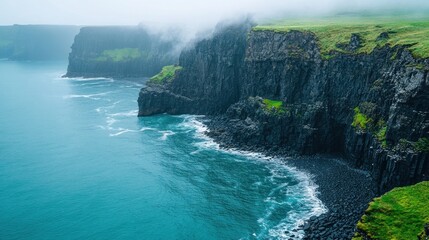 Wall Mural - Foggy cliffs meet ocean waves, green coast, dramatic seascape.