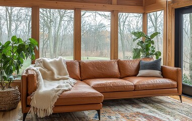 Poster - Tan leather sectional sofa in sunroom with plants and natural light.