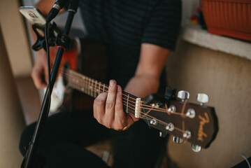 Man's hand playing acoustic guitar.