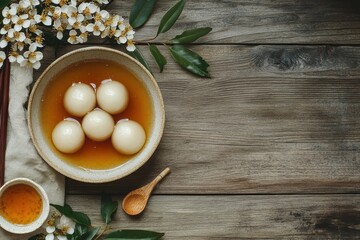 Wall Mural - Small white glutinous rice balls in syrup with osmanthus honey in a bowl on a wooden table