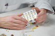 © vizafoto - A young doctor examines medical pills. Close-up.