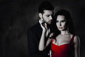 Poster - Portrait of pretty charming woman with curly hair decollete virile harsh man with stubble embracing hugging having serious expression isolated on grey background with copy space empty place