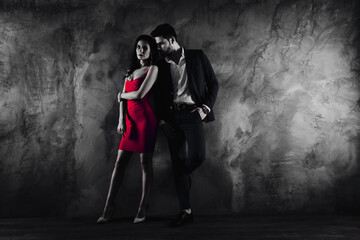 Poster - Full size body portrait of attractive couple charming slim lady in purple dress gentlemen in tuxedo holding hand in pocket looking at lover standing near grey wall background