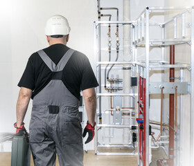 Poster - man plumber near pipes. utility repair specialist. indoor water pipes. sewer pipe repair specialist.