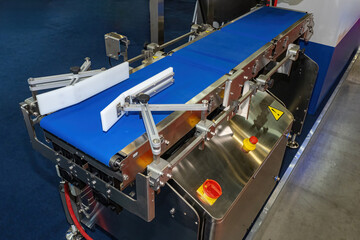 Poster - Packaging conveyor line. Blue production tape. Industrial conveyor on steel frame. Conveyor belt is stretched on roller. Automation of production. Technologies for accelerating industrial processes
