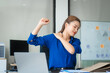 © Phushutter - Asian businesswoman sits at her ergonomic desk, working on a laptop and mobile phone. Her posture ensures minimal strain, addressing neck pain, back pain, and preventing repetitive strain injuries.