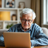 Happy eldery man with laptop in apartment interior.