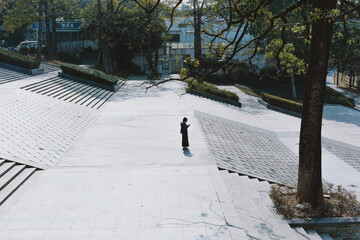 In winter, a girl stands in Dongguan Botanical Garden waiting for a date