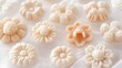 © milenialdesastudio - Assorted pastel floral-shaped candies on white fabric.