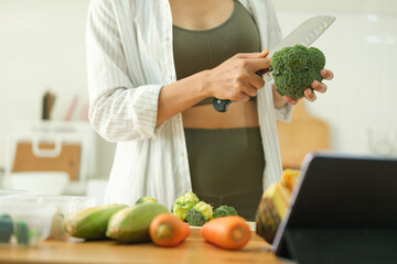 Wall Mural - Cropped shot young woman prepares fresh ingredients for a week's worth of healthy meals in a modern kitchen