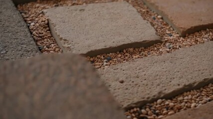 Poster - Square and rectangular pavers form a permeable surface, with small gaps filled with gravel, creating a durable and environmentally friendly pavement