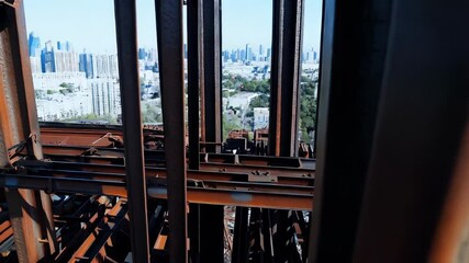 Aufkleber - Steel beams framing high rise construction gradually shifting focus, revealing modern cityscape with sunlight illuminating urban architectural landscape