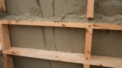 Aufkleber - Wooden formwork detaching from concrete wall surface, exposing textured construction material with distinct contrast between wood framework and finished cement structure