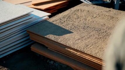 Aufkleber - Construction materials, including reusable formwork panels and other building supplies, lie on the ground at a construction site, awaiting use in a building project