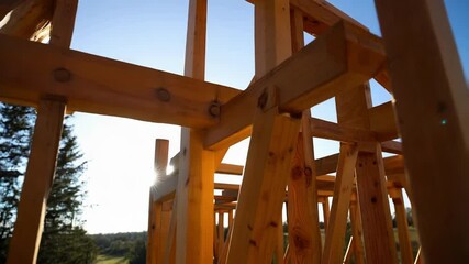Aufkleber - warm sunlight casting golden hues over emerging timber frame structure, highlighting meticulous wood