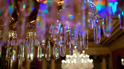 Aufkleber - Ornate chandelier with iridescent crystal prisms hanging in a grand hall, reflecting rainbow colors and creating a mesmerizing display of light and shadow