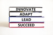 © Dzmitry - Innovate adapt lead succeed symbol. Concept words Innovate Adapt Lead Succeed on beautiful books. Beautiful white table white background. Business innovate adapt lead succeed concept. Copy space.