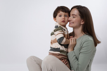 Canvas Print - Happy mother with her cute little son on white background, space for text