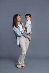 Canvas Print - Happy mother with her little son on grey background