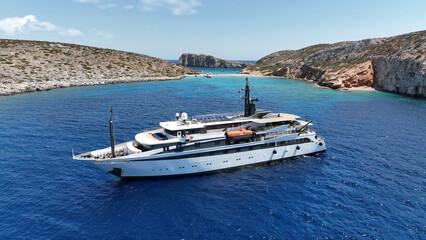 Wall Mural - Aerial drone photo of luxury yacht anchored in tropical exotic island bay with emerald sea and secluded sandy beaches