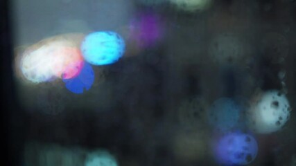 Wall Mural - raindrops on the window against the blurred background of the night city bokeh effect