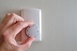 © JackCA - hand adjusts room temperature regulator