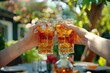 © sidqi - Detailed Picture of Friends Toasting Iced Tea Glasses at Outdoor Table