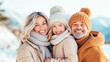 © OlgaKhorkova - Smiling caucasian family in warm winter clothing enjoying snowy day outdoors.