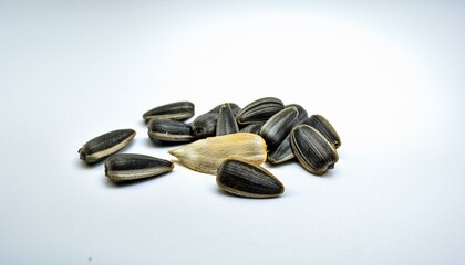 Canvas Print - A small pile of sunflower seeds on a white background.