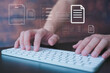 © cherdchai - Man hands typing on wireless computer keyboard, Document data system Report HR technology Concept: Businessman Manager checking white documents reports papers of files icon in modern office