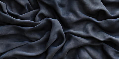 The image shows a close-up of a dark, textured fabric with deep folds and wrinkles