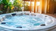 © Pannee - A pool with a jacuzzi feature surrounded by a luxurious home and tropical landscaping.