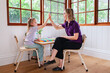 © Austockphoto - Speech therapist professional with child in clinic high five together to celebrate success