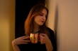 © Cavan - Young woman enjoying a warm beverage in a cozy setting